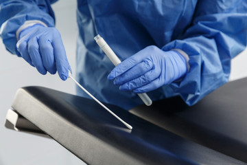 Laboratory expert in gloves  takes bacterium or dna analysis of a surface.