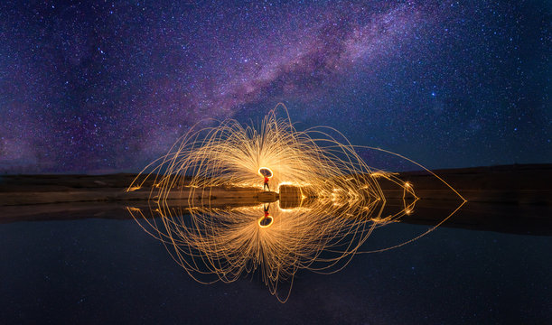 Amazing Fire Show at night .The fire show and a lot of the bright sparks in the night.Play a beautiful and exciting fire.Dark light. panorama view .Long exposure light .
