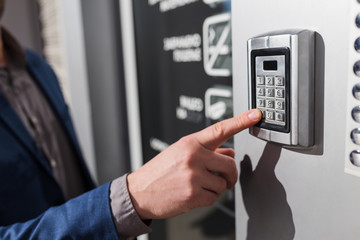 Man hand pressing the security code combination to unlock the door