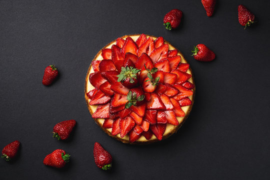 Strawberry Cheesecake top view from above. A classic decadent dessert, this sweet and delicious homemade baked cheesecake is topped with fresh strawberry slices. The perfect cake for a birthday!