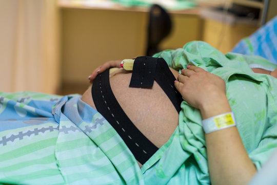 Pregnant woman in hospital with cardiotocography bell
