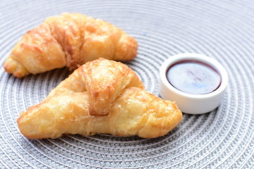 Small butter croissant, accompanied by blackberry jam