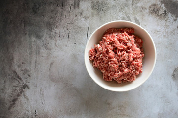 Bowl of Fresh Raw Ground Beef on a Concrete Table