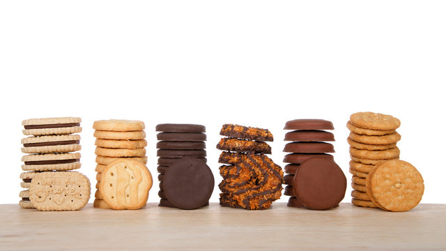 Alameda, CA - April 19, 2019: Stacks of popular Girl Scout cookies, Available annually during Girl Scout cookie sales, on a wood table with white background.