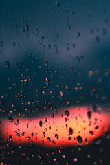 Image of raindrops on the window with warm sunset colors in the background