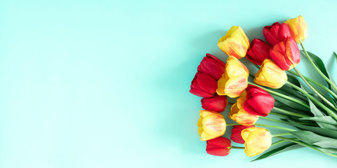 Beautiful composition of spring flowers. Yellow and red tulips flowers on pastel blue background. Valentine's Day, Easter, 8th march, Mother's Day. Flat lay, top view, copy space
