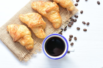 Small butter croissant, accompanied by coffee