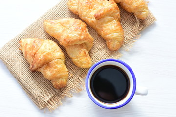 Small butter croissant, accompanied by coffee