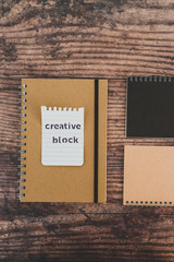 creative block or writer's block, notepads on wooden desk with text doodle on piece of paper
