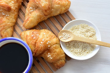 Small butter croissant, accompanied by coffee