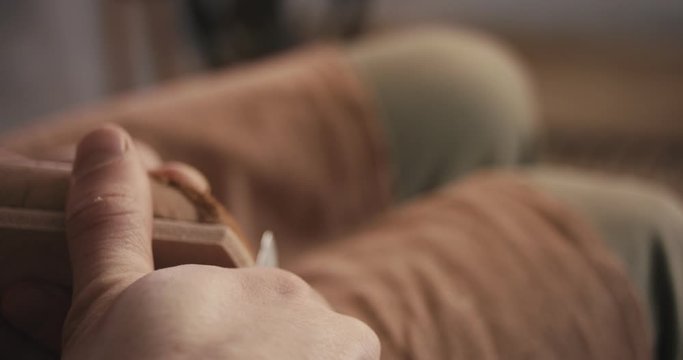 Traditional bespoke shoemaker cutting shaping leather insole on wooden shoe last with knife close up