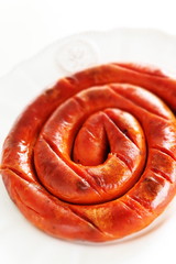 Round sausage on dish for cooking 