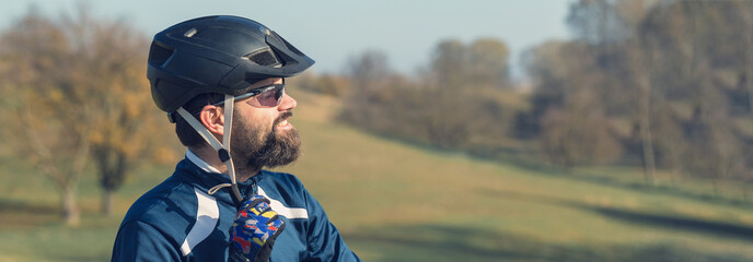 Cyclist in pants and fleece jacket on a modern carbon hardtail bike with an air suspension fork. The guy on the top of the hill rides a bike.