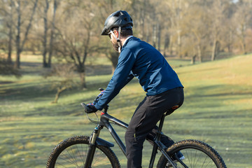 Cyclist in pants and fleece jacket on a modern carbon hardtail bike with an air suspension fork. The guy on the top of the hill rides a bike.