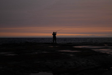 silhouette of man fishing