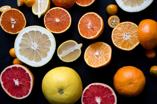 Various sliced citrus fruits on a dark background