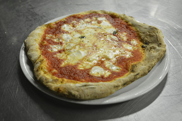 pizza napoletana servita in un piatto in pizzeria