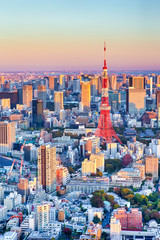Obraz premium Spektakularny widok na panoramę Tokio w Blue Hour w Japonii z linią drapaczy chmur i słynną wieżą Tokyo Tower na pierwszym planie.