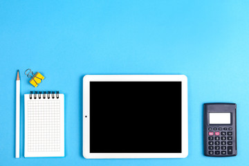 workspace top view. office Desk with office supplies, calculator and tablet computer. side view blue background