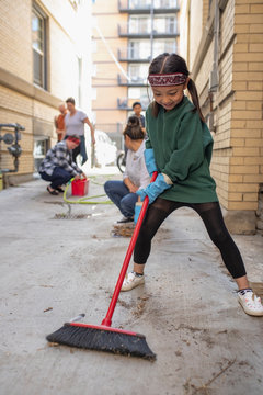 Cute Girl With Broom Helping Neighbors Clean Apartment Alley