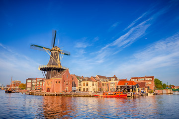 Tourist Travel Destinations. Attractive View of Harlem Sight With De Adriaan Windmill on Spaarne River On The Background