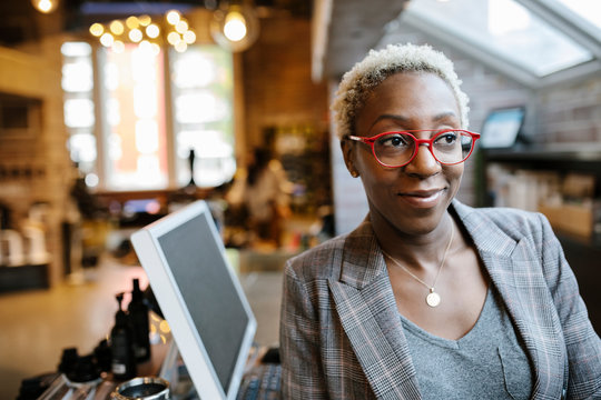 Portrait of female store owner wearing red eyeglasses smiling
