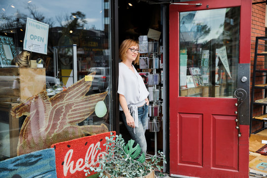 Female business owner standing in doorway of gift shop