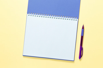 open notebook with pen on yellow background