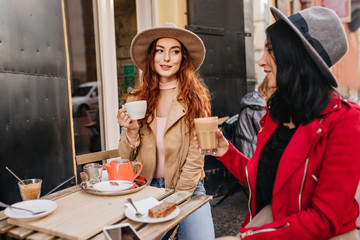 Romantic ginger girl have lunch with best friend in warm autumn weekend. Portrait if two ladies in...