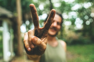 Happy gardener man giving the peace sign 