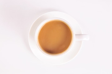 White cup of creamy coffee isolated on blue background. Top view.