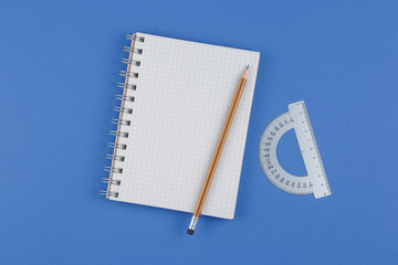 school notebook with a pencil on blue table