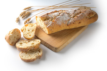 Baguette or French bread baked with onions on a wooden cutting board on a white background, copy space