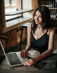 Business woman working on a laptop in a cafe.