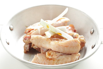 Seasoning chicken wing and onion on pan