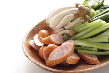 Sausage, Komatsuna green leaf and shimeji mushroom on wooden plate