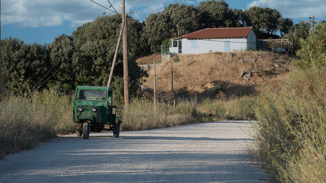 Green 3 wheeled vehicle parked on the side of the road