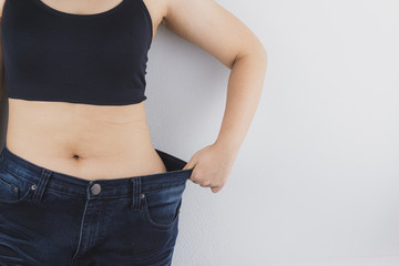 Close up shot of woman with slim body showing her diet results. Healthy nutrition, diet and weight...