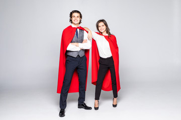Young couple of superheroes in costumes standing with crossed arms and looking at camera isolated on white background