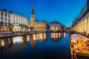 Scenic panoramic twilight view of famous Hamburg city center with illuminated historic town hall reflecting in Binnenalster on a beautiful summer evening during blue hour at dusk, Germany