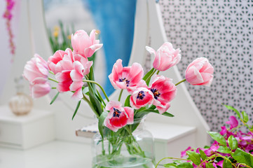Delicate pink tulips in a transparent vase. A gift for a girl, a gift for mom, a gift for a woman. Spring flowers