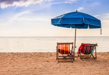 Couple on a tropical beach at island,couple on island vacation holiday relax the sun on their deck chairs under a beach umbrella in thailand