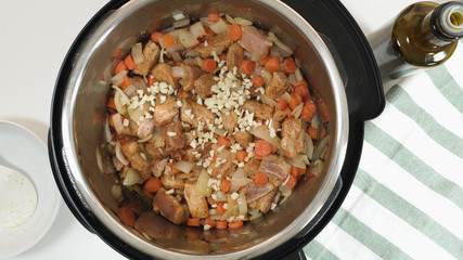 Cooking rice with meat and vegetables  in pressure multi cooker step by step. Add choped garlic.