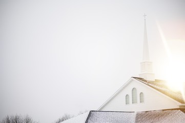Low angle shot of a church with a staple under the bright sky