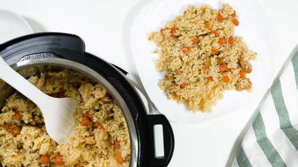 Rice, vegetables, and meat in a pot and on a plate. Cooking rice with meat and vegetables (or Rice Pilaf)  in pressure multi cooker step by step, top view.