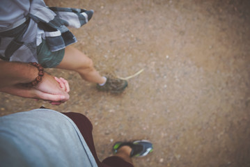 A couple hand in hand walking along a trail