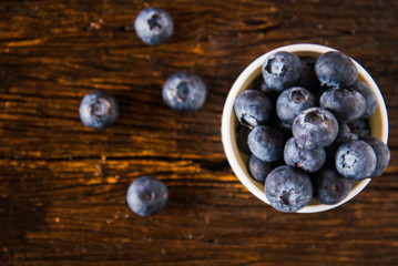 blueberries in a bowl on wooden table
