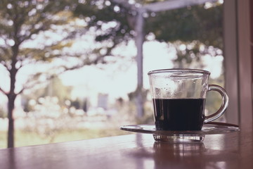 hot black coffee in drinking glass put on table
