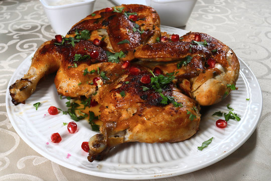 Pan fried crispy chicken tabaka served on a white plate, shallow focus