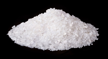 Pile of sea salt isolated on black background.